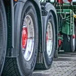 Rzędy kół ciężarówek na placu, transport linii produkcyjnych bez przestojów i relokacji